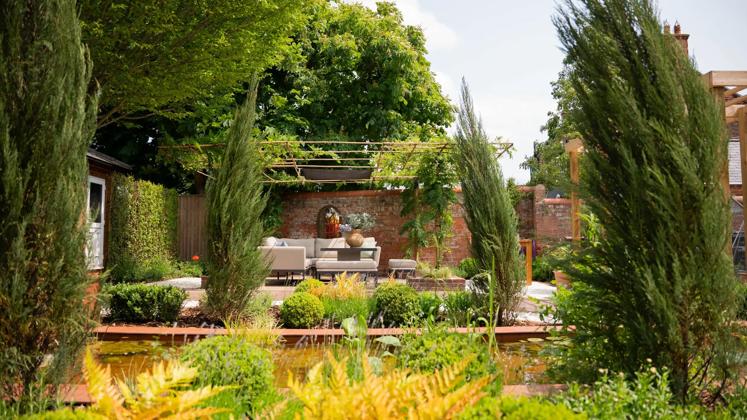 Zoning in garden in Grimsby with seating area next to pond